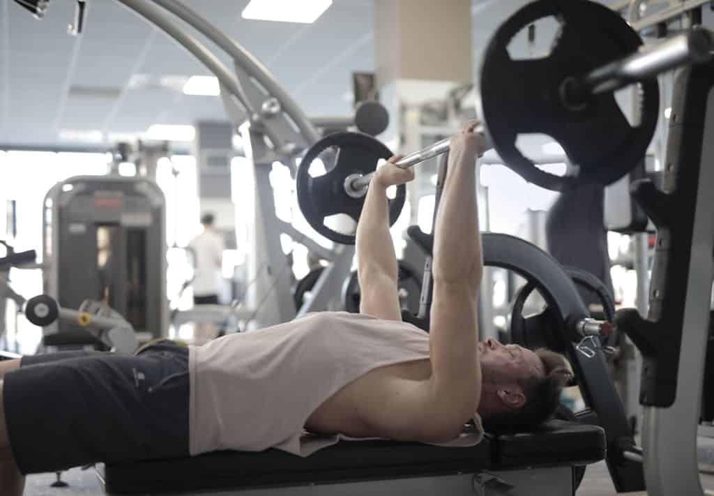 Photo by Andrea Piacquadio Muscular sportsman training with heavy barbell during weightlifting workout in modern gym