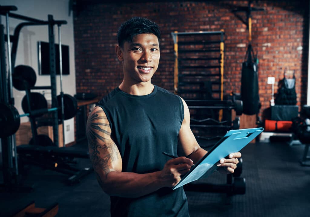 Would you like to be a member. Shot of a personal trainer holding a clipboard