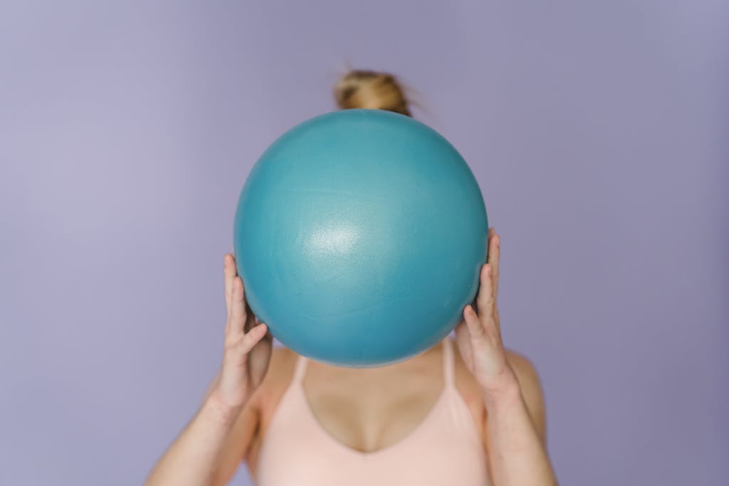 Unrecognizable sportive woman with fit ball
