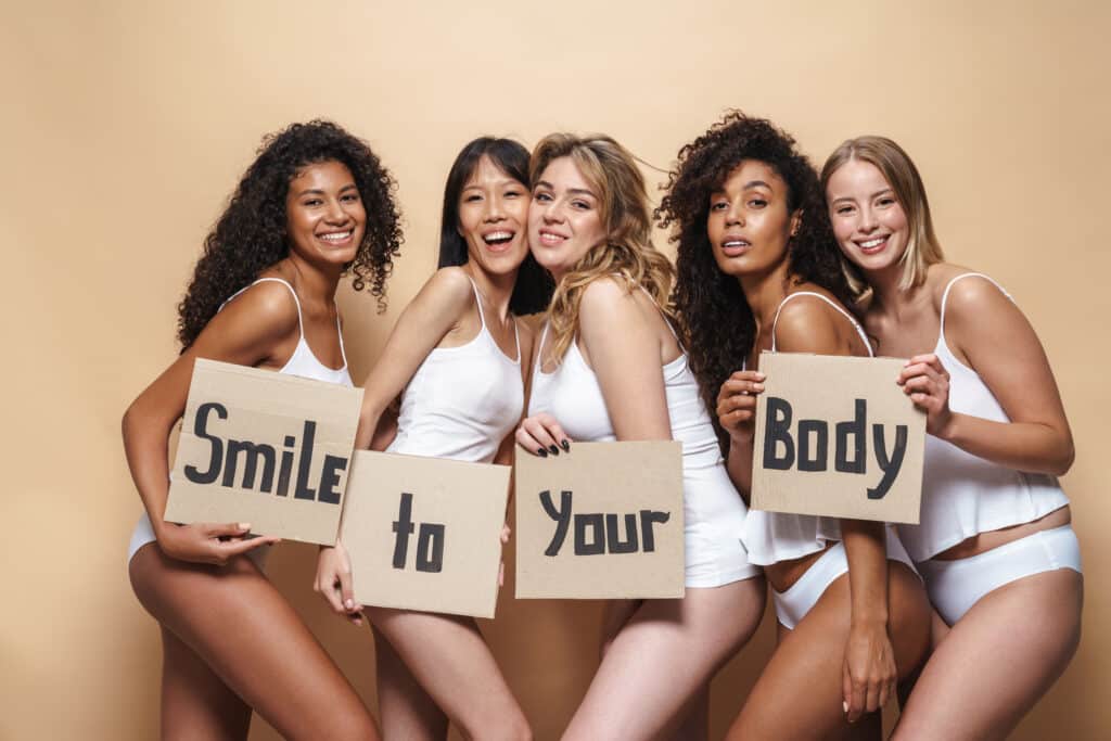 Image of pleased multinational women posing with placards
