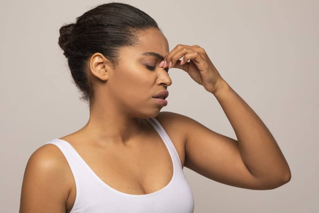 Tired black woman touching nose bridge, have migraine, copy space