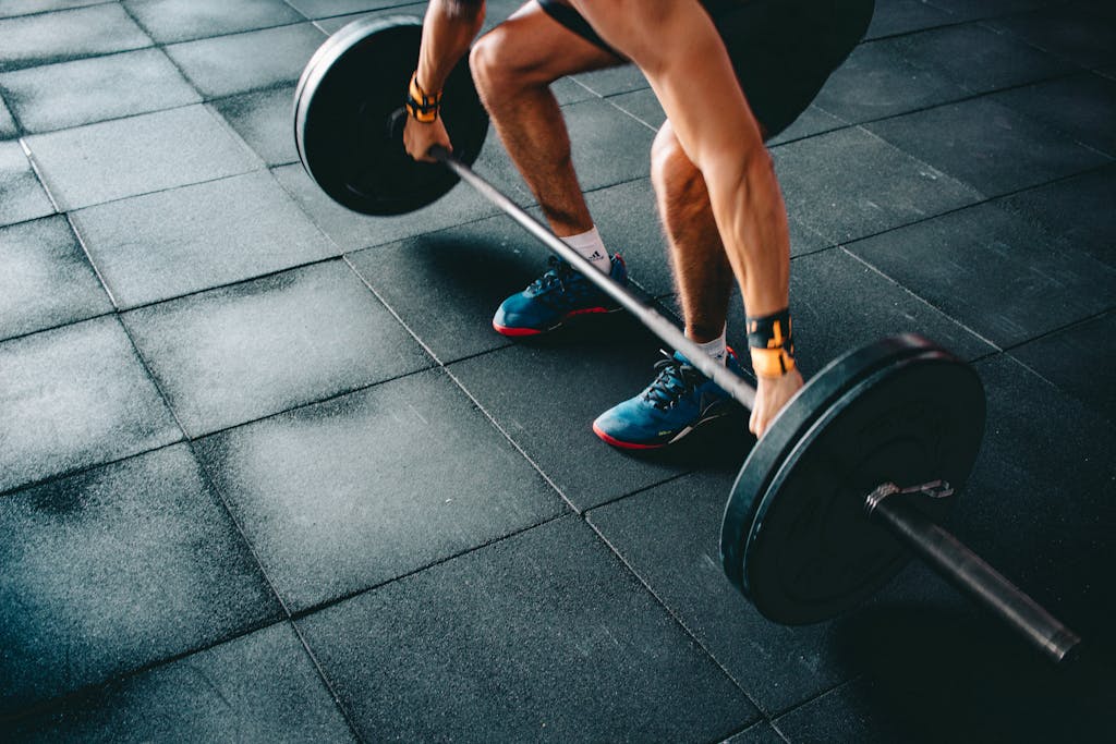 Photo by Victor Freitas Person Holding Barbell