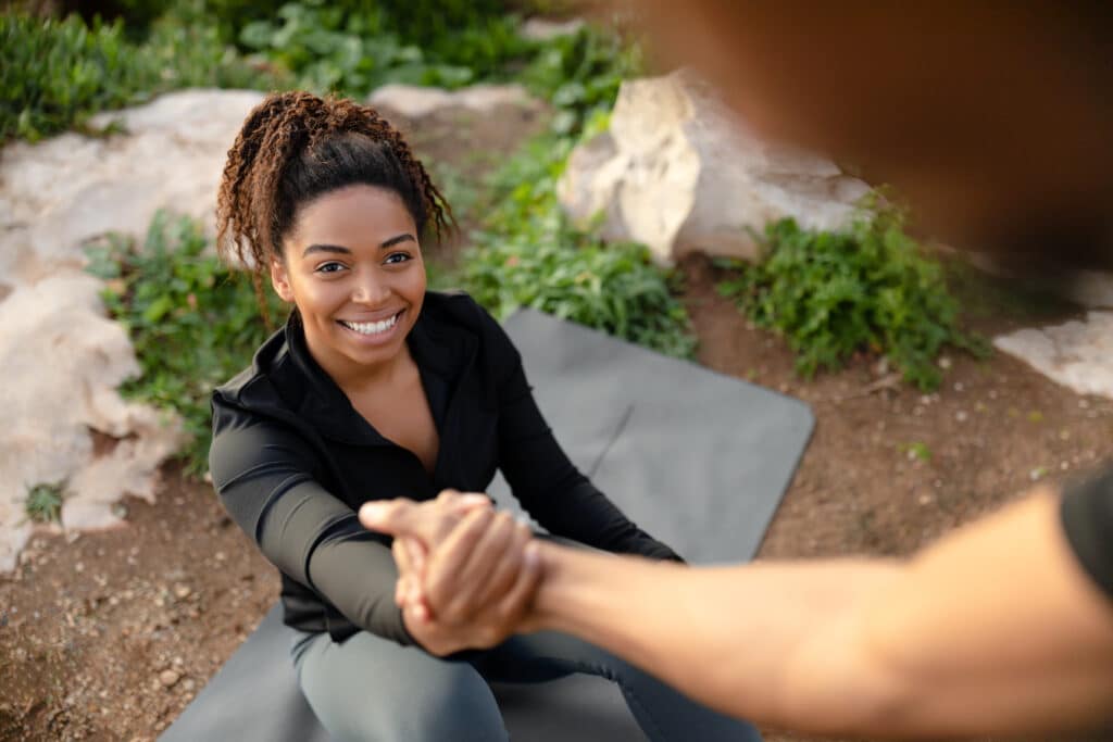 Millennial african american man helping to pretty wife get up from mat, enjoy workout in morning Millennial african american man helping to pretty wife get up from mat, enjoy workout in morning