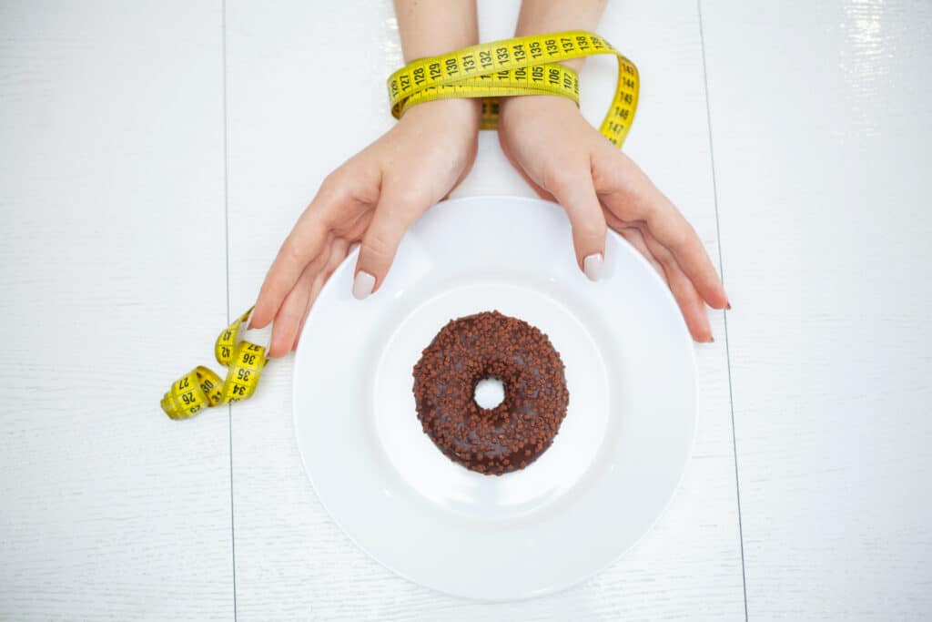 Diet or weight control concept. Centimeter tape and fork on a white background with a place for inserting text. concept of health, weight loss, diet, proper nutrition