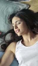 Photo of Woman in White Tank Top Lying on Bed