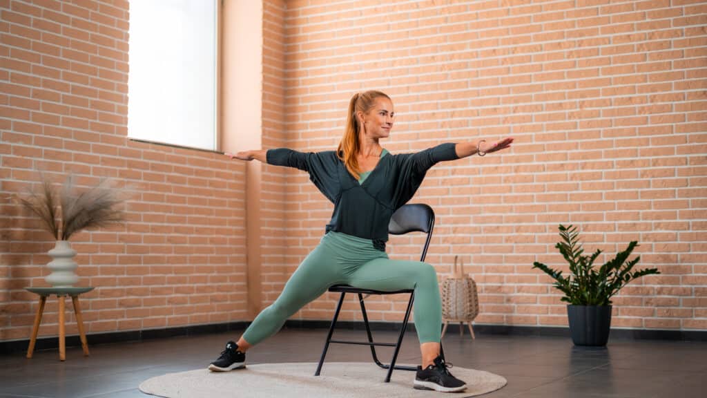 woman doing warrior pose with chair