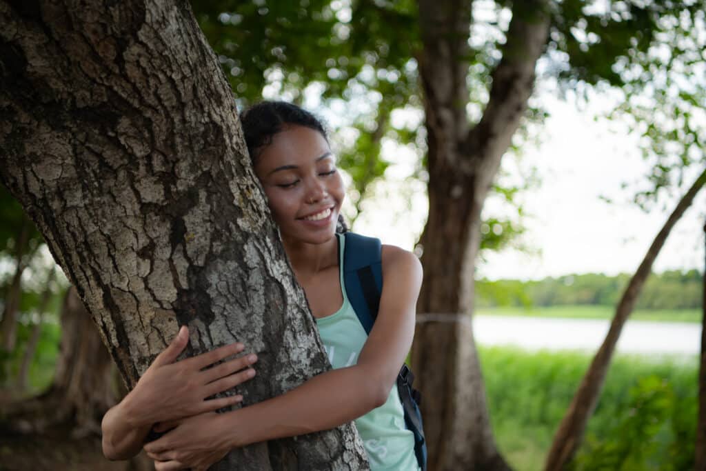 Portrait of a beautiful young woman with backpack standing and f
