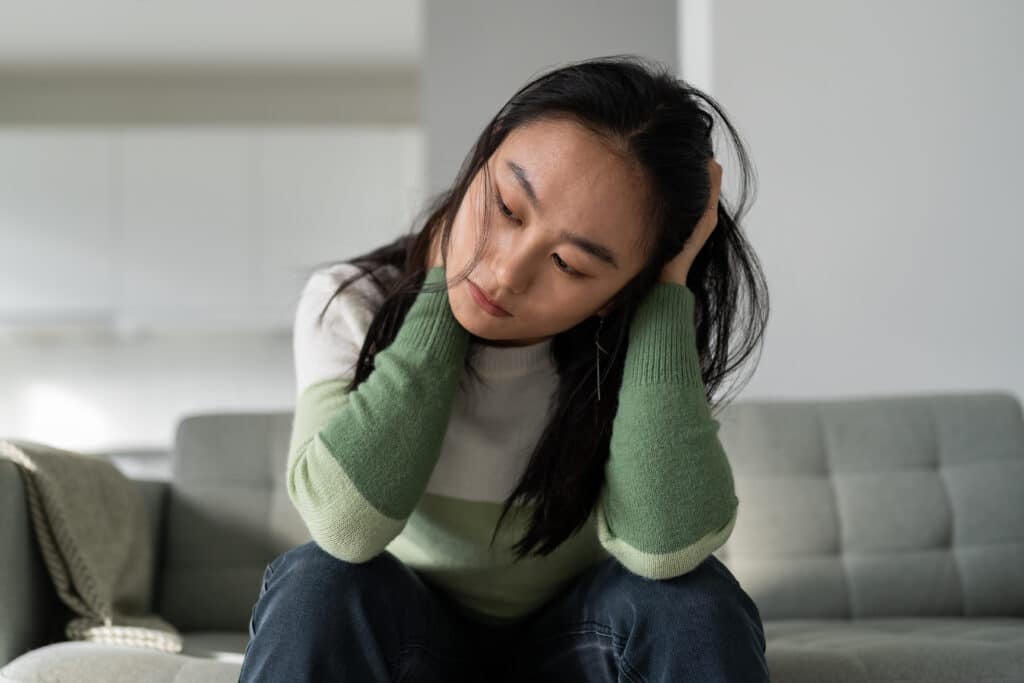 Unhappy depressed young Asian woman feeling sad and lonely after breakup or divorce