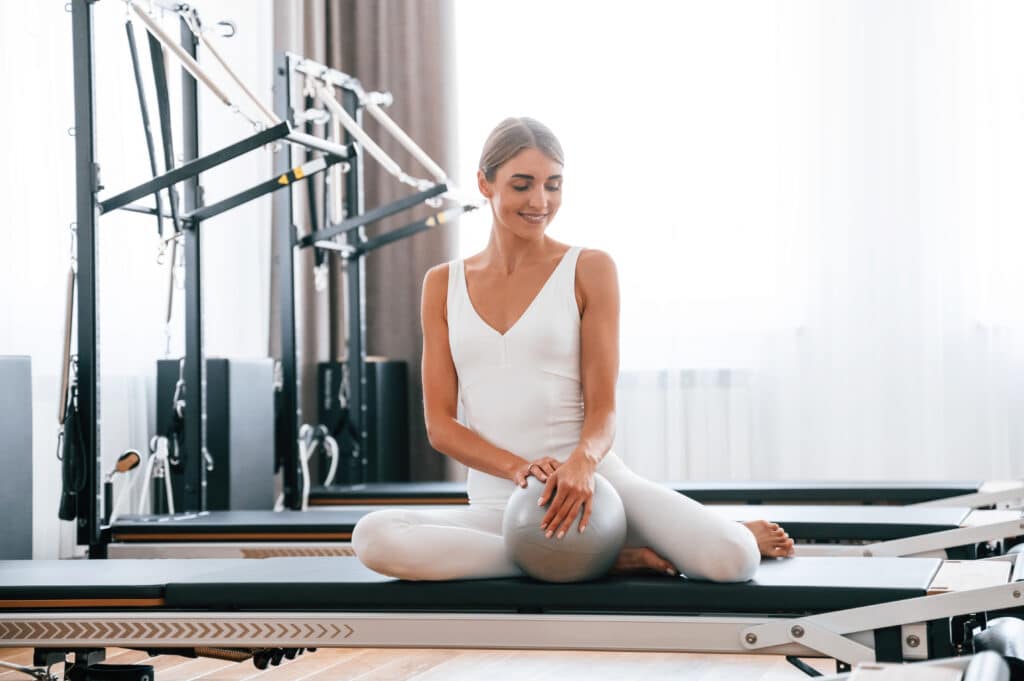 Using fitness ball. Young woman is doing exercises