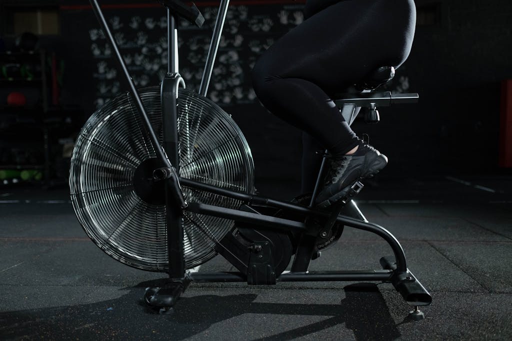 Tabata Ride: A High-Intensity Workout for Maximum Results Person in Black Pants Using a Stationary Bicycle