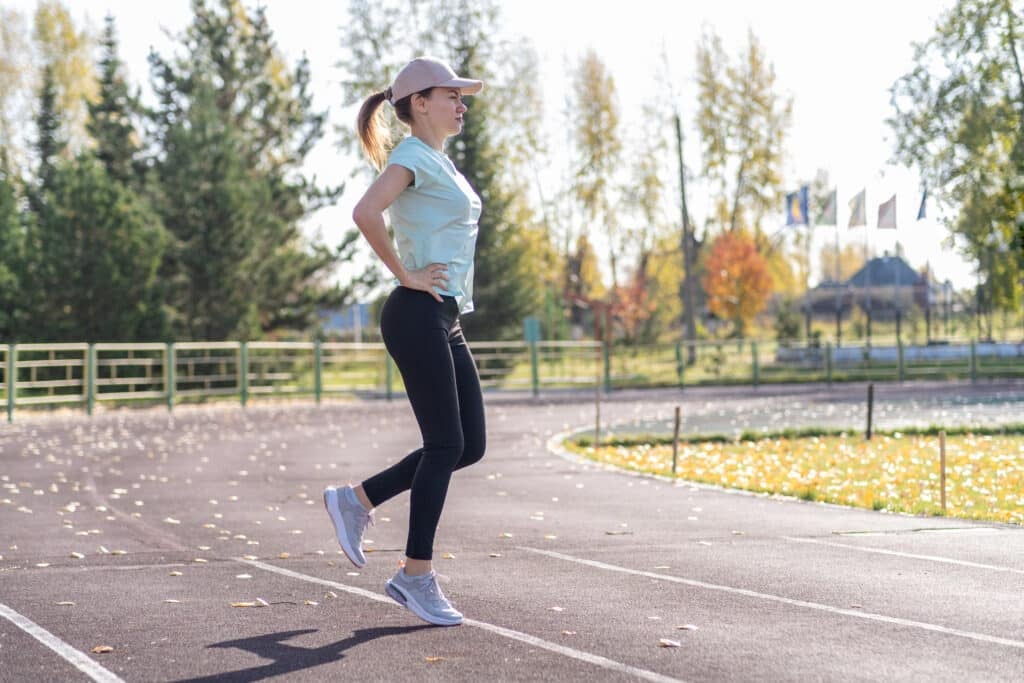 A young beautiful woman in sportswear plays sports at a local stadium