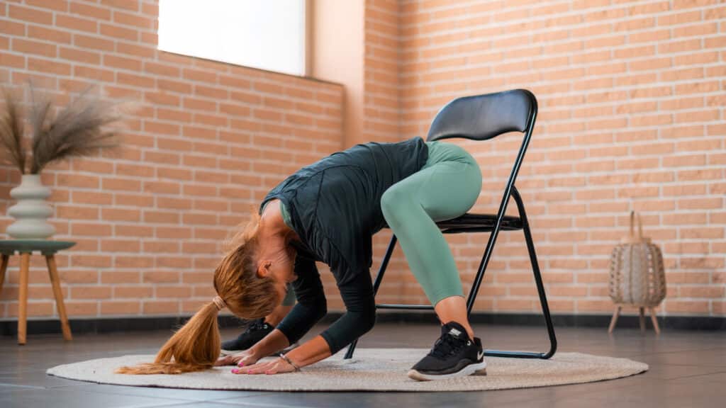woman doing child pose on chair