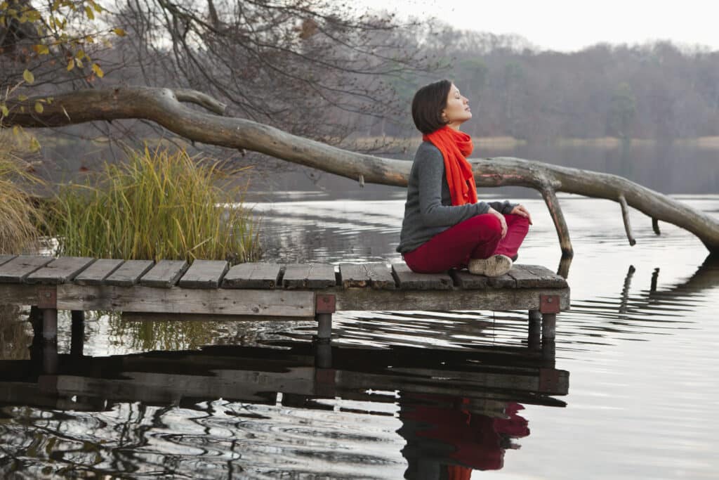 Germany, Berlin, Wandlitz, Mid adult woman sitting on pier