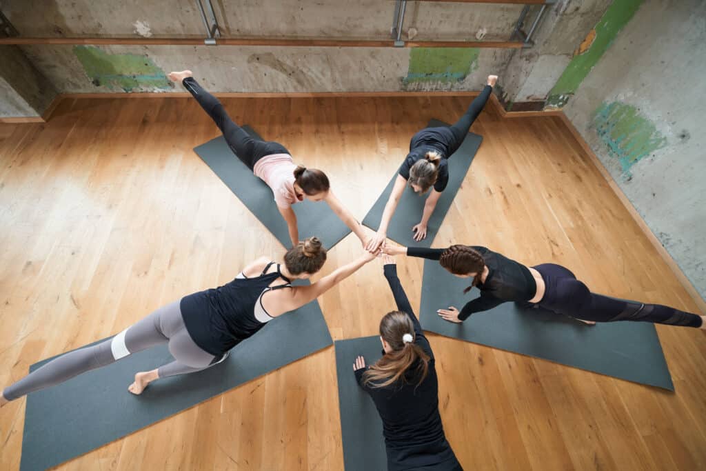 Group of women stretching in hall. Group of women stretching in hall.