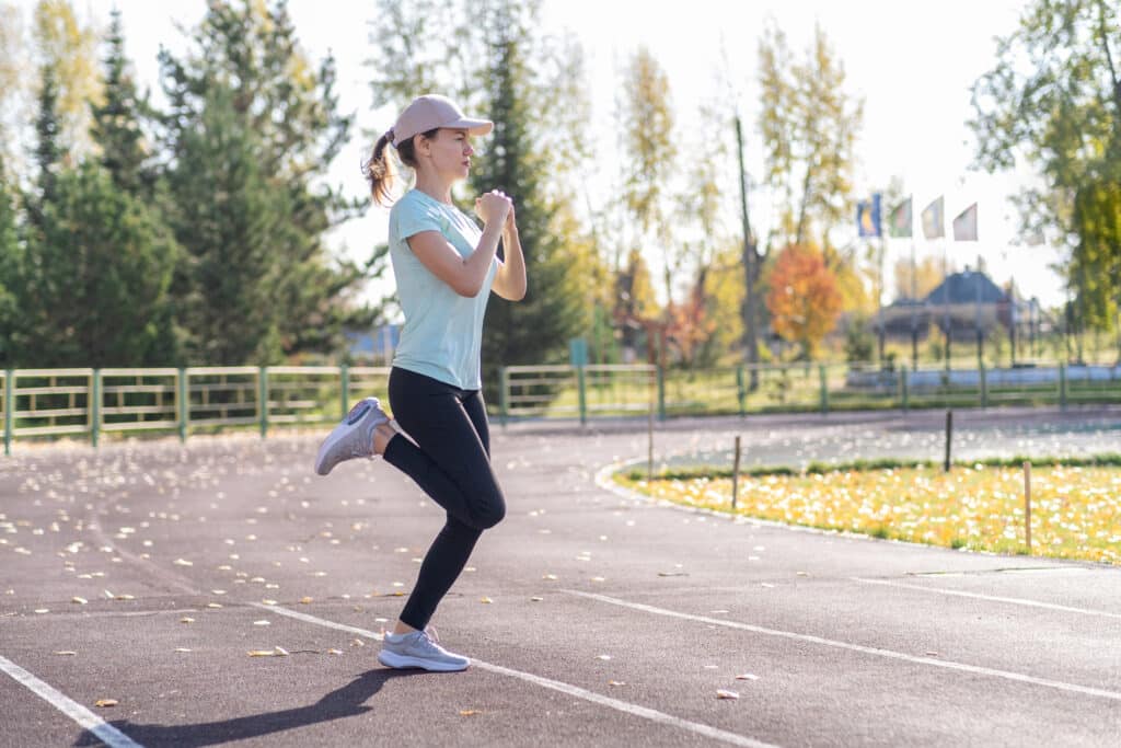 A young beautiful woman in sportswear plays sports at a local stadium