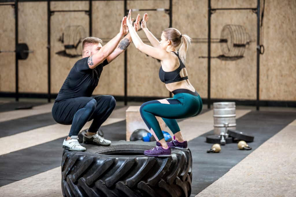 Couple training with tire n the gym Couple training with tire n the gym