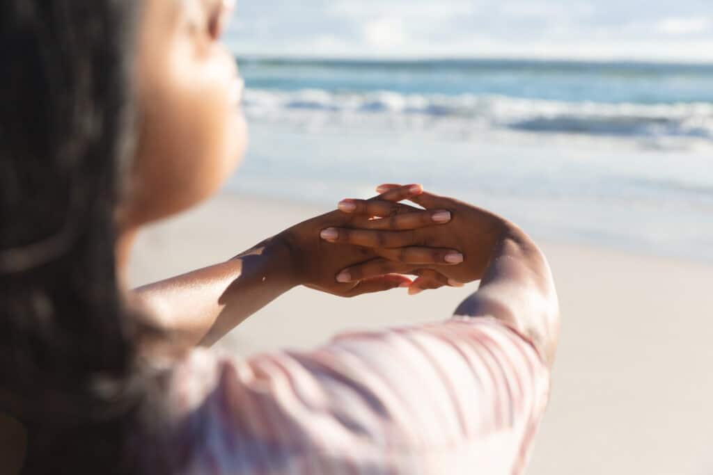 Mixed race woman on beach holiday stretching hands. outdoor leisure vacation time by the sea. Mixed race woman on beach holiday stretching hands. outdoor leisure vacation time by the sea.