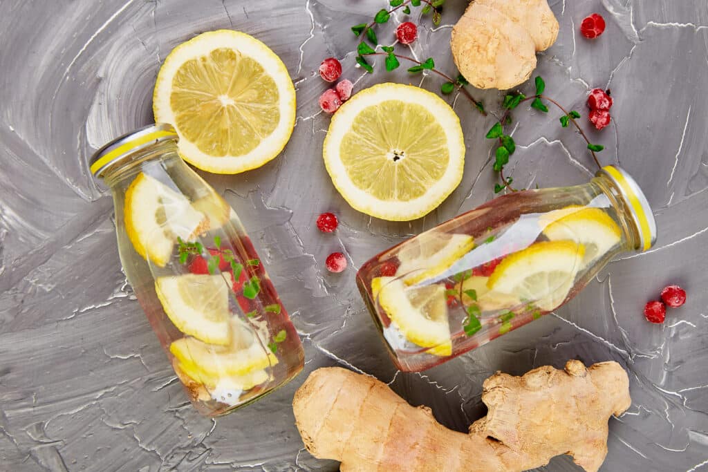Detox water in bottles with cranberrie, ginger, lemon, mint