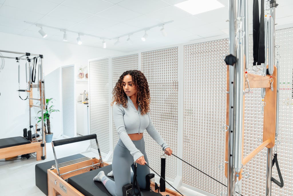 How Much Are Pilates Classes: A Comprehensive Pricing Guide Woman on a Pilates Tower