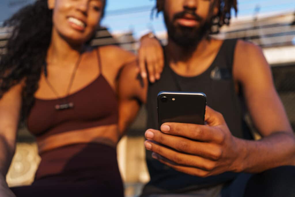 Smiling young afro american couple using mobile phone