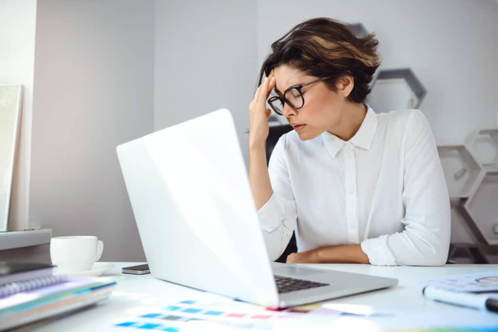 Woman covered her face with her hands due to workplace stress - Zen2Fit Corporate Wellness