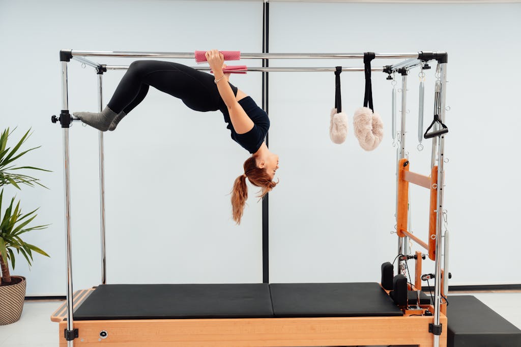 How Much Are Pilates Classes: A Comprehensive Pricing Guide Woman Hanging on Metal Poles