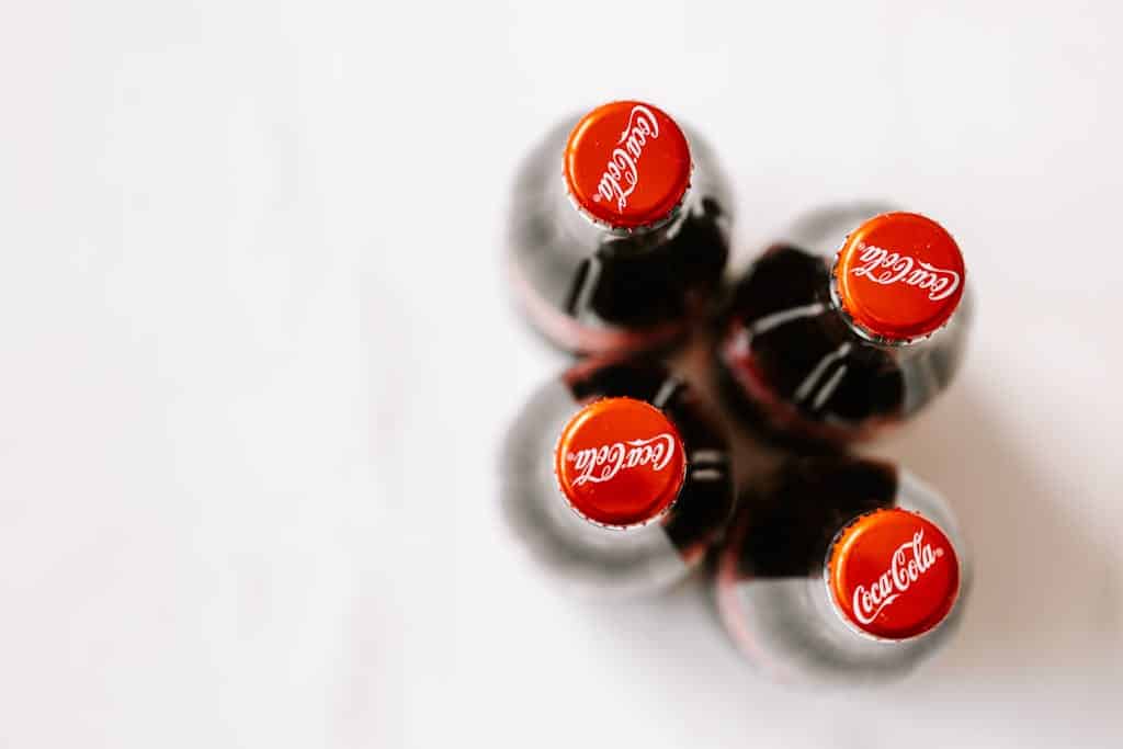 Bottles of Coca-Cola placed on white surface
