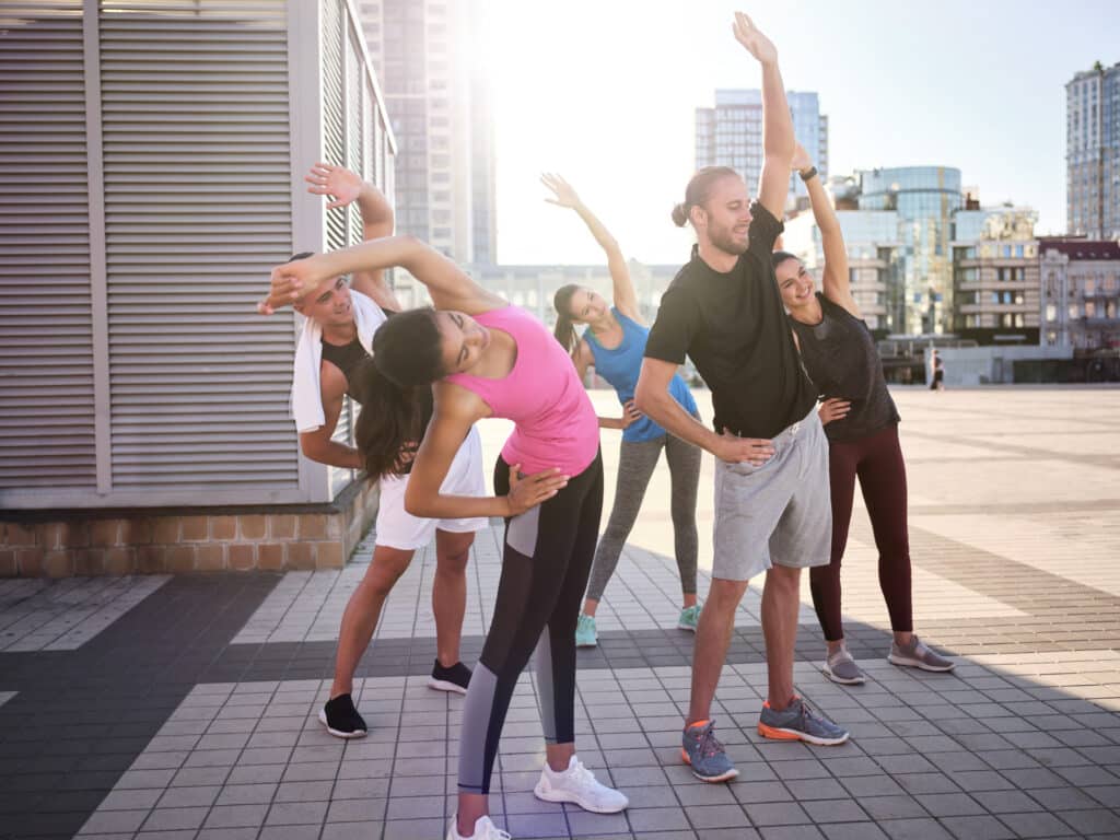 Young multiracial team warming up before workout Young multiracial team warming up before workout