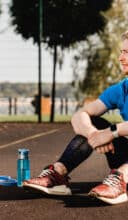 Healthy strong 25s man resting after workout on sportsground