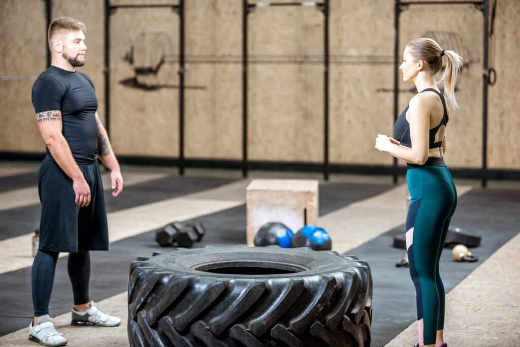 Couple training with tire n the gym Couple training with tire n the gym