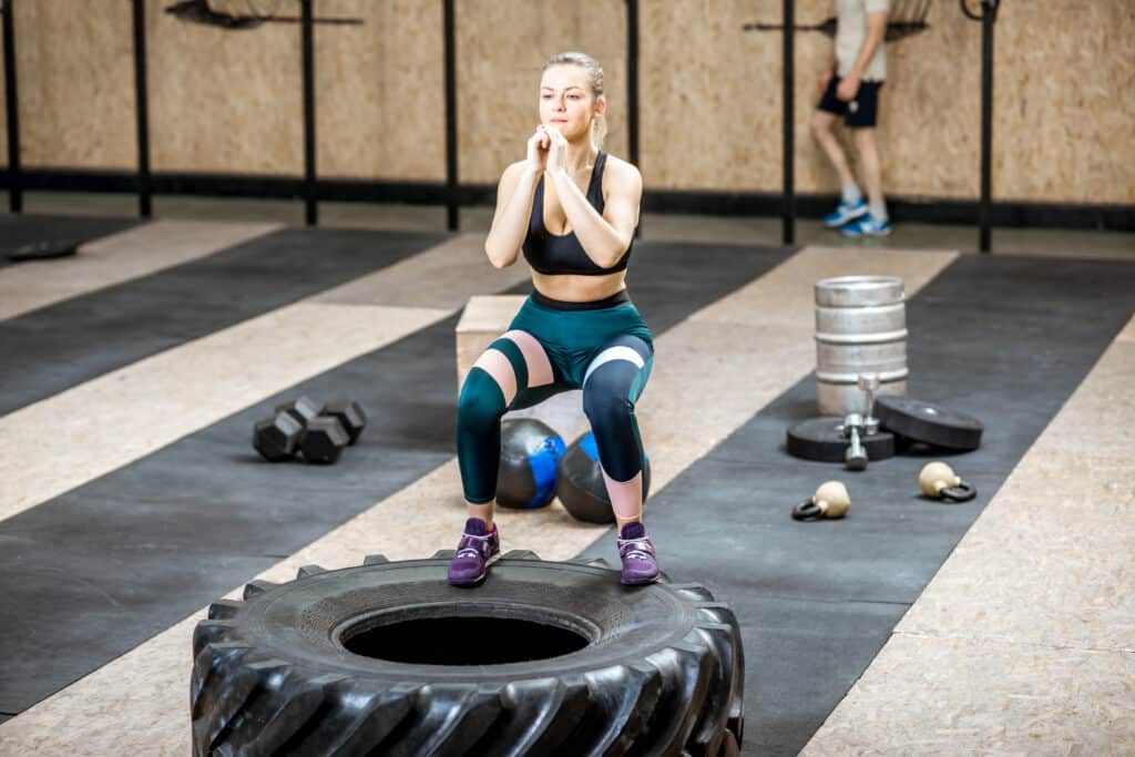 Woman training with a tire in the gym Woman training with a tire in the gym