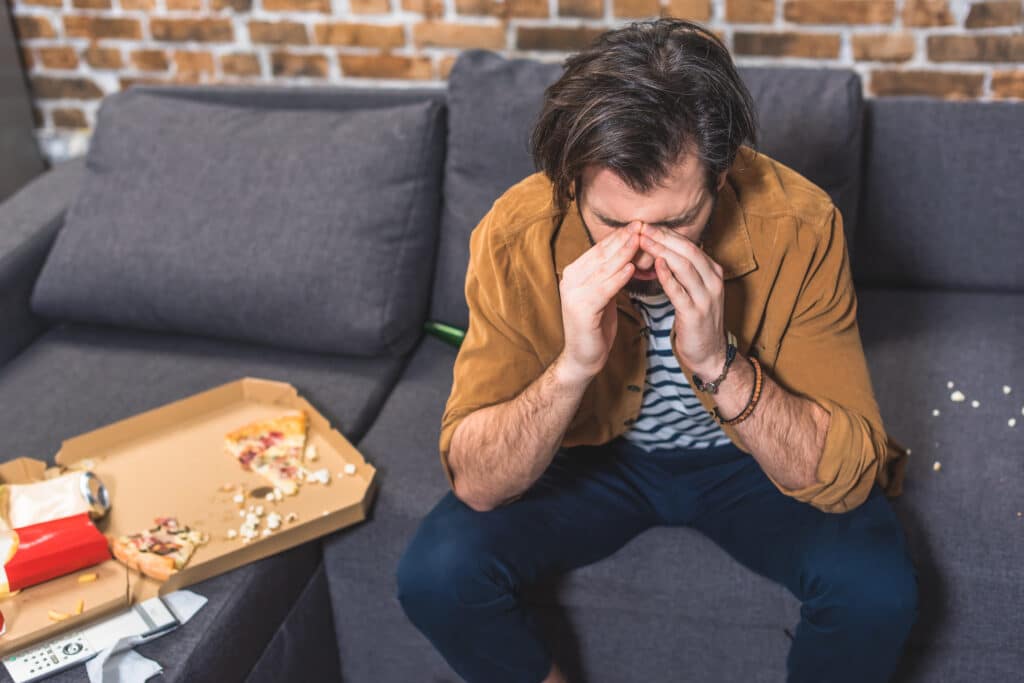 handsome loner having headache in morning and touching nose bridge at living room