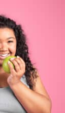 a woman holding a green apple