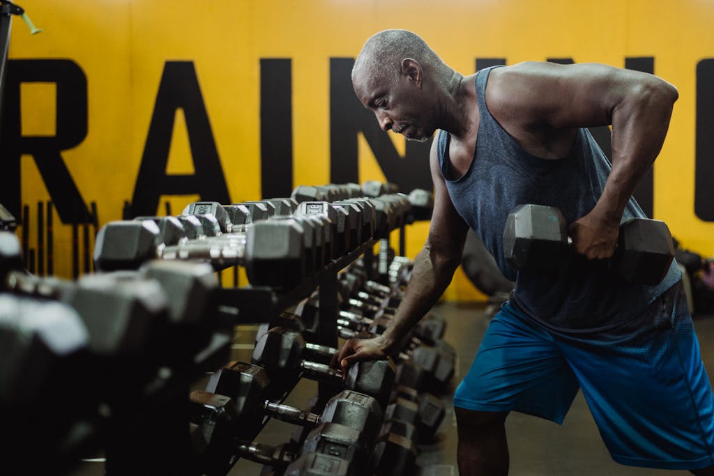 Photo by Ketut Subiyanto Man in Blue Tank Top Exercising With a Dumbbell