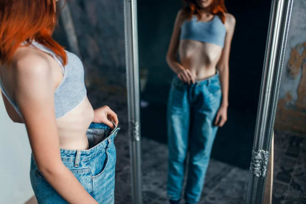 Thin woman tries on big size jeans, weight loss