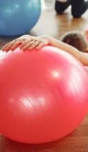 woman practicing pilates with ball