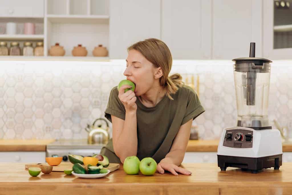 Snack Traps: How Mindless Munching Sabotages Your Diet Woman Leaning on Counter Top