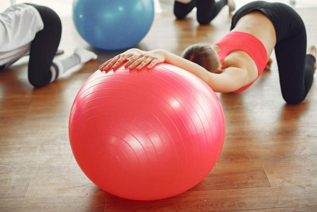 woman practicing pilates with ball
